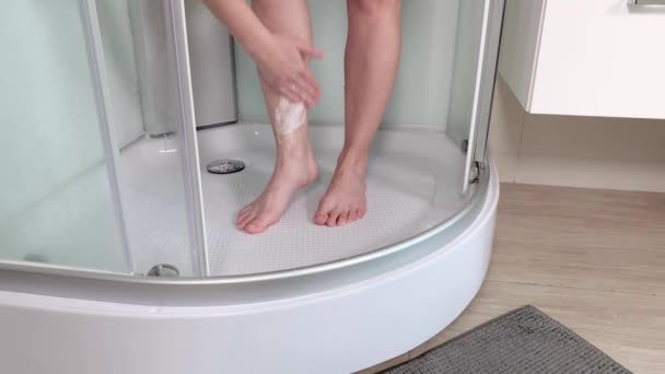 セクシーな若い女性のシャワーの小屋で泡で彼女の脚を剃るします 女性の脚のクローズ アップ表示 少女の手が浴室で彼女の脚をそり — ストック動画