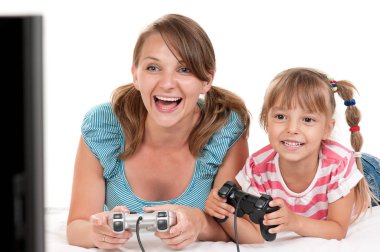 Anne ve kızı oyun çubukları ve Video oyunları oynarken konsolda bir arada tutan. Mutlu aile - anne ve küçük kız beyaz arka plan üzerinde oyun eğleniyor. Bilgisayar oyunu oynayan çocuk kadınla.