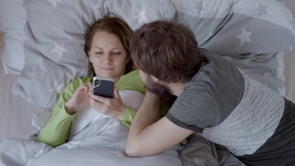 Paar liegt im Bett — Stockvideo