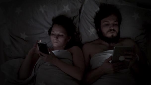 Pareja usando el teléfono celular en la cama — Vídeos de Stock