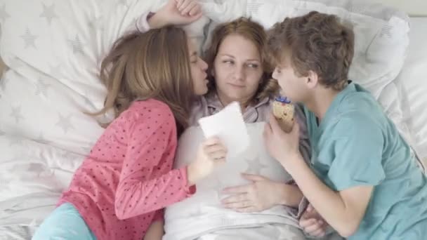 Mother with son and daughter in bed — Stock Video