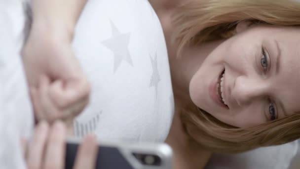 영상입니다 스마트 폰으로 셀카를 아름다운 카프카스 소녀가 웃으며 카메라를 감정들 — 비디오