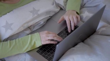 Yatak Odası, dizüstü bilgisayarda çalışan kadın. Eller sabah yatakta dinlenirken üstünde Laptop klavye tuşlarına basarak kapatın. Yan görünüm.