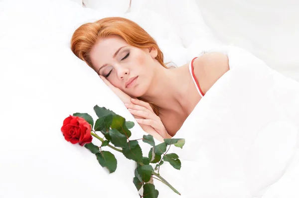 Flicka med rött hår på en säng — Stockfoto