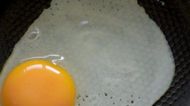 Yumurta sıcak tavaya atılıyor. Kırık tavuk yumurtası tavaya düşer. Tavada yumurta pişiriyorum. Üst görünüm yakın plan.