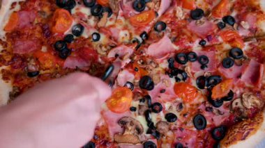 Yakın plan yeni pişmiş pizza kesimi. Özel bıçaklı ve dilimlenmiş kadın eli. Lezzetli pizza alır..