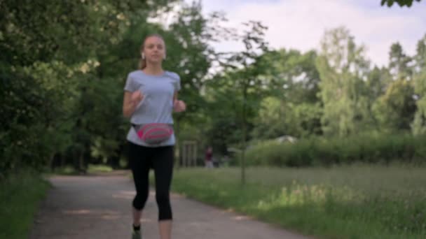 Tonåring Med Hörlurar Lyssnar Musik Och Kör Offentlig Grön Park — Stockvideo