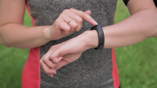 Mujer Con Auriculares Enciende Música Reloj Inteligente Corriendo Parque Verde — Vídeo de stock