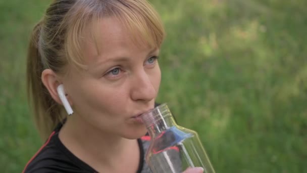 Młoda Kobieta Słucha Muzyki Pije Wodę Treningu Lub Bieganiu Widok — Wideo stockowe