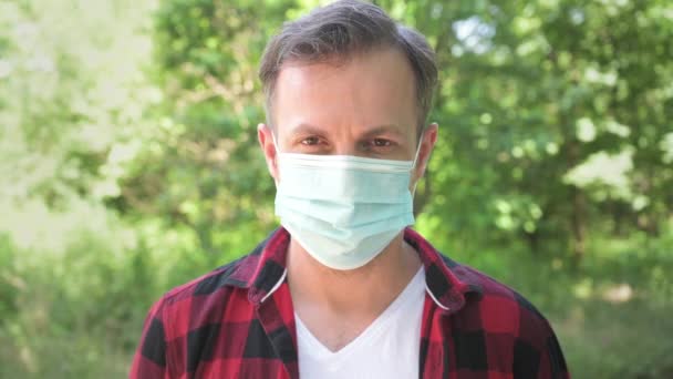 Porträtt Ung Man Tar Medicinsk Ansiktsmask Och Ler Glad Kaukasisk — Stockvideo