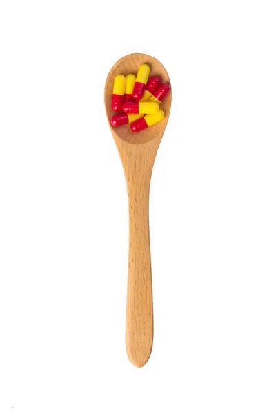 Pills in wooden spoon — Stock Photo, Image