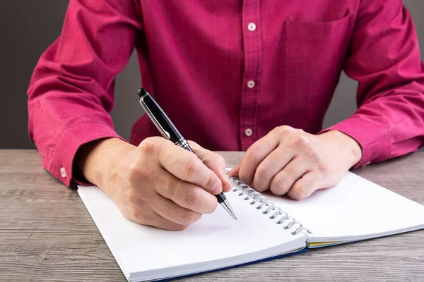 Mann Schreibt Auf Notizbuch Und Arbeitet Auf Holztisch — Stockfoto