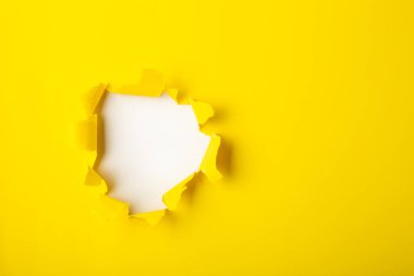 Yırtılmış delik ve yırtılmış sarı kağıt beyaz arkaplan metni için boşluk.