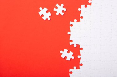 Kırmızı arka planda beyaz yapboz parçaları var. Metin için boşluk