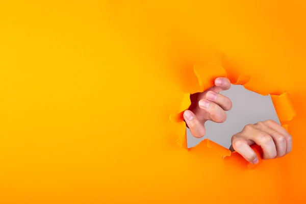 Manos Rasgando Agujero Papel Naranja Con Los Bordes Rotos — Foto de Stock