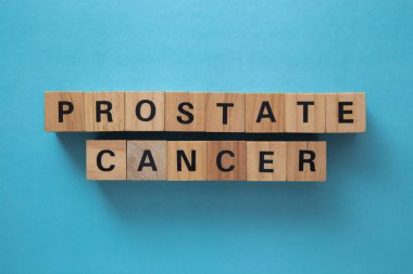 Wooden cubes spelling prostate cancer promoting awareness on a blue background