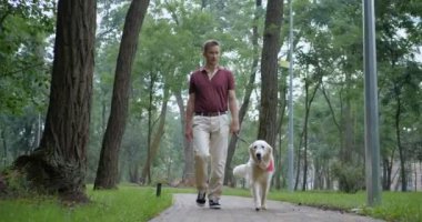 Golden Retriever köpek ile birlikte parkta yürüyüş Goldeowner ile yürüme sahibi