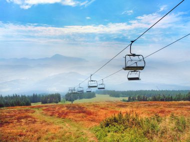 A colorful meadows with road and cableway at Kubinska Hola mountain, with the Great Choc mountain and other Chocsky Hills seen in the distance. The Orava region is popular vacation destination located north of the Dolny Kubin, northern Slovakia. clipart