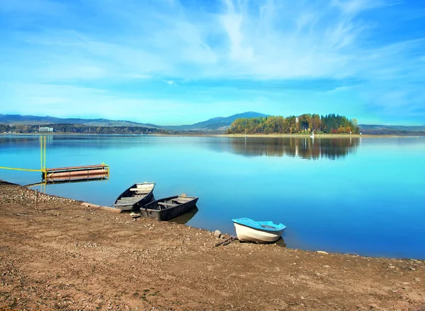 小さな手漕ぎボートと遠くに見える Slanica の島の海岸の水景 Slanica 最北端のスロバキアの Namestovo の町の近くの Orava 貯水湖にあります Slanica — ストック写真