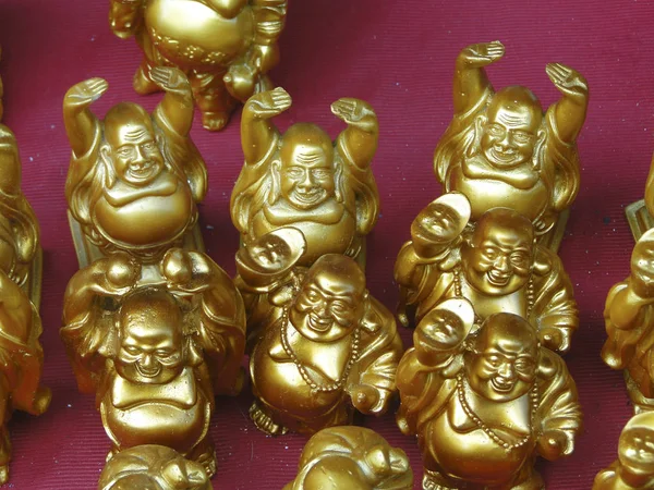 Golden laughing buddhas  outside the Tirupati temple