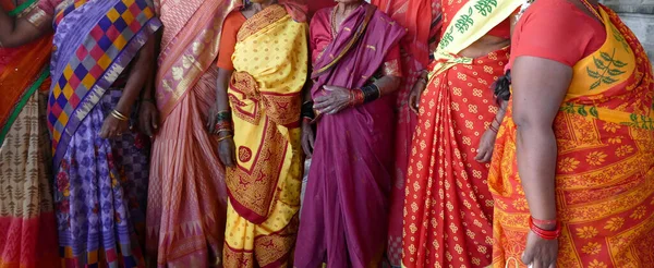 KANCHIPURAM, INDIA - DEC 26, 2019 - Women pilgrims wear red sarees in the Maha Mandapa meeting hall of the Ekambareshwara Temple, Kanchipuram, Tamil Nadu , India