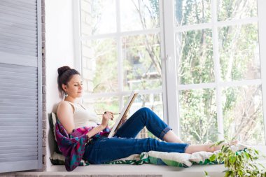 Parlak gün ışığı Studio resim üzerinde çalışan kadın sanatçı