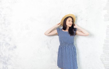 Mutluluk. Mutlu yaz kadın şapka ve gri arka plan üzerinde mavi elbise