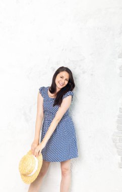 Mutluluk. Mutlu yaz kadın şapka ve gri arka plan üzerinde mavi elbise