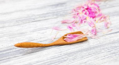 pembe şakayık yaprakları rustik bir arka plan üzerinde tahta kaşıkla. Alan, üstten görünüm kopyalayın. Çiçek kompozisyon.