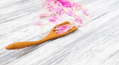 pembe şakayık yaprakları rustik bir arka plan üzerinde tahta kaşıkla. Alan, üstten görünüm kopyalayın. Çiçek kompozisyon.