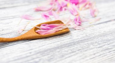 pembe şakayık yaprakları rustik bir arka plan üzerinde tahta kaşıkla. Alan, üstten görünüm kopyalayın. Çiçek kompozisyon.