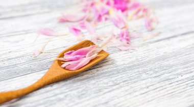 pembe şakayık yaprakları rustik bir arka plan üzerinde tahta kaşıkla. Alan, üstten görünüm kopyalayın. Çiçek kompozisyon.