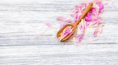 pembe şakayık yaprakları rustik bir arka plan üzerinde tahta kaşıkla. Alan, üstten görünüm kopyalayın. Çiçek kompozisyon.