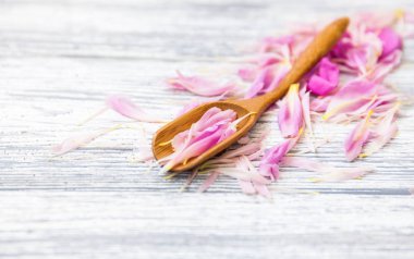 pembe şakayık yaprakları rustik bir arka plan üzerinde tahta kaşıkla. Alan, üstten görünüm kopyalayın. Çiçek kompozisyon.