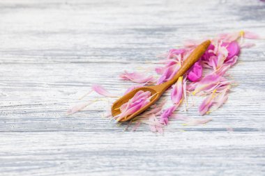 pembe şakayık yaprakları rustik bir arka plan üzerinde tahta kaşıkla. Alan, üstten görünüm kopyalayın. Çiçek kompozisyon.