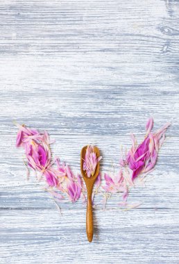 pembe şakayık yaprakları rustik bir arka plan üzerinde tahta kaşıkla. Alan, üstten görünüm kopyalayın. Çiçek kompozisyon.