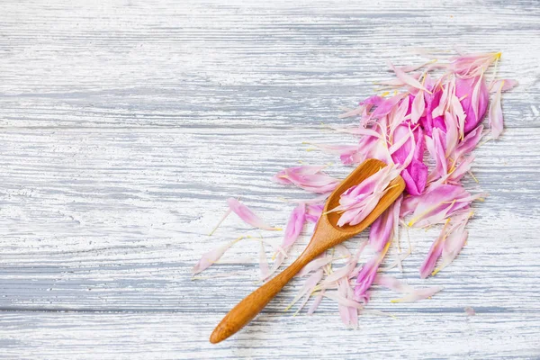 pembe şakayık yaprakları rustik bir arka plan üzerinde tahta kaşıkla. Alan, üstten görünüm kopyalayın. Çiçek kompozisyon.