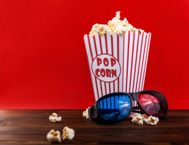 Sinema arka plan. Filmi izlerken. Gözlük, içki, patlamış mısır ve Klaket üzerinde kırmızı zemin üstten görünüm alanı Kopyala