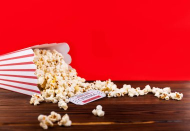 Kırmızı ve beyaz kova patlamış mısır iki kırmızı film bilet ile. Film gecesi kapatmak kırmızı üzerine