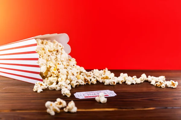 Kırmızı ve beyaz kova patlamış mısır iki kırmızı film bilet ile. Film gecesi kapatmak kırmızı üzerine