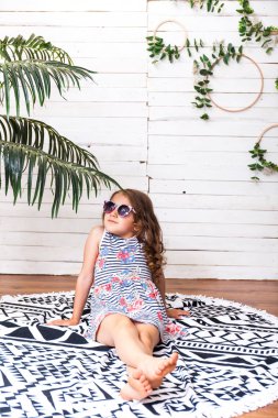 Bir plaj halı rüya denizin üzerinde kalan üzerinde gözlük, küçük bir kız. Macera ve seyahat kavramı.