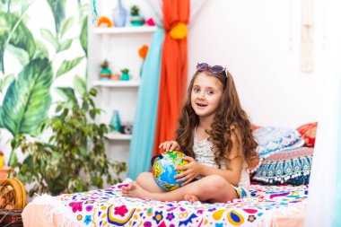 Sevimli küçük kız şirin Arapça iç bir küre tutuyor. Seyahat kavramı.