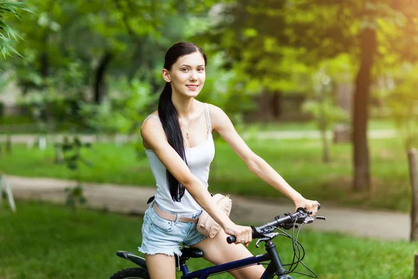 Güzel kız bir şehir parkı bir bisiklet sürme. Aktif insanlar. Açık havada