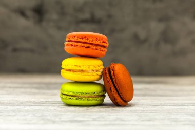 Ahşap arka plan üzerinde renkli acıbadem kurabiyesi yığını