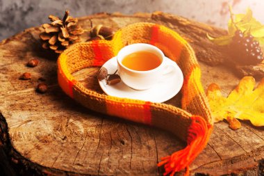 Üstten görünüm ile sıcak örme eşarp boşaltmak, seçici odak, düz ile koyu ahşap rustik tabloda çay yatıyordu