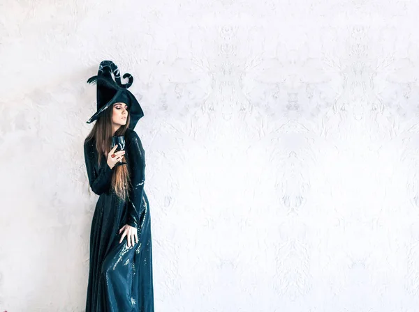 ハロウィーン ゴージャスな若い魅力の肖像画黒ドレスと古代の城に灰色の背景上の黒いガラスで帽子の美しい女性吸血鬼バロック貴族魔女 — ストック写真