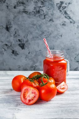Domates suyu Mason kavanoza ve taze üzüm domates bütün ve yarısı rustik masa