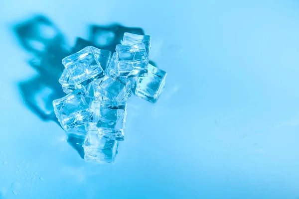 湿的冰在蓝色背景上的多维数据集 — 图库照片