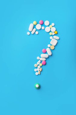 Beyaz arka plan üzerinde bir soru işareti şeklinde hapları