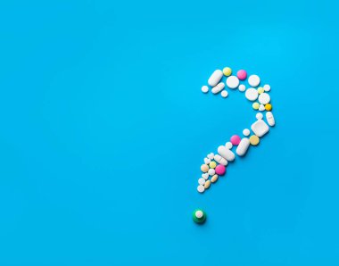 Beyaz arka plan üzerinde bir soru işareti şeklinde hapları